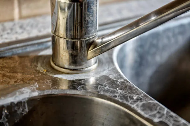 Mineral scale built up around a faucet